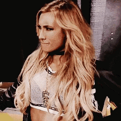 a woman with long blonde hair and a choker is wearing a crop top and necklace .