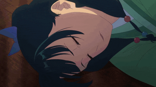 a close up of a person laying down with their eyes closed and a blue bow in their hair