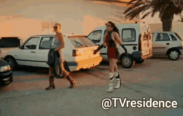 a couple of women walking down a street with the words @tvresidence written above them