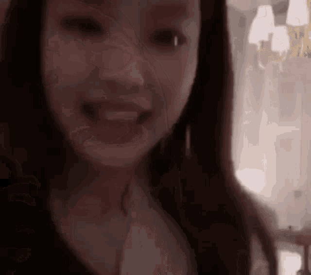 a woman is smiling and looking at the camera in a room .