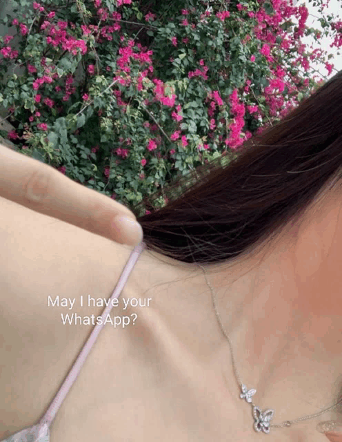 a woman wearing a necklace with a butterfly on it says may i have your whatsapp?