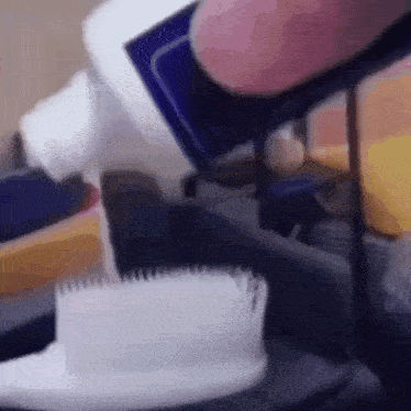 a person is pouring toothpaste into a toothbrush .