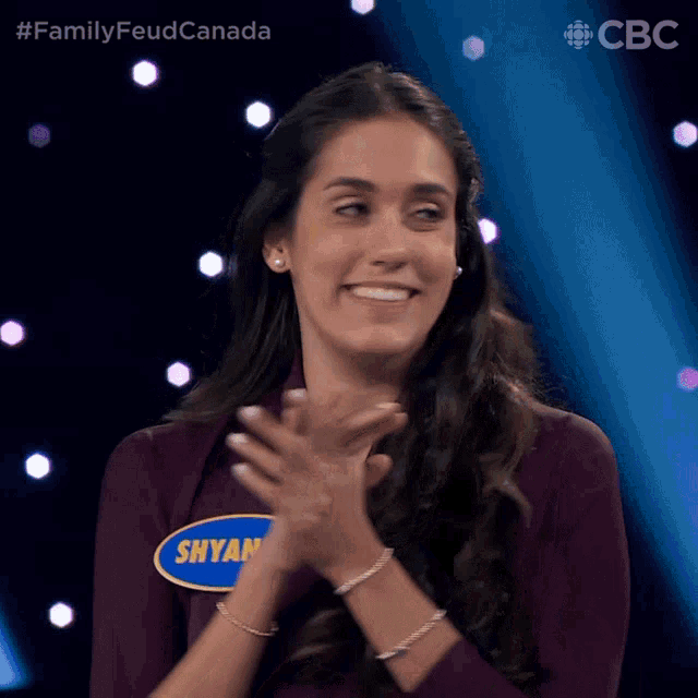 a woman with a name tag that says shyam clapping her hands
