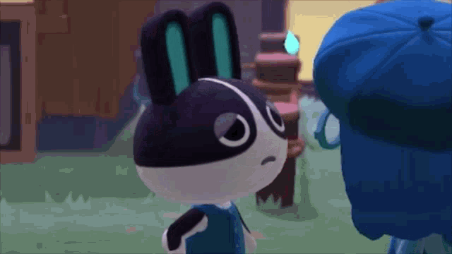 a black and white rabbit is standing next to a person in a blue hat .