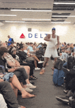 a man in a white tank top is running in front of a delta sign