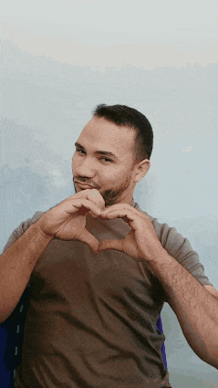a man with a beard is making a heart with his hands