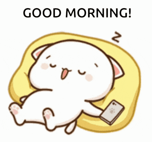 a cartoon cat is sitting on a pillow looking at a cell phone and saying good morning .