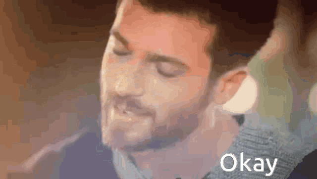 a close up of a man with his eyes closed and the word okay written next to him