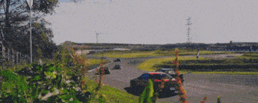 a race car with a license plate that says ' nz ' on it is driving down a track