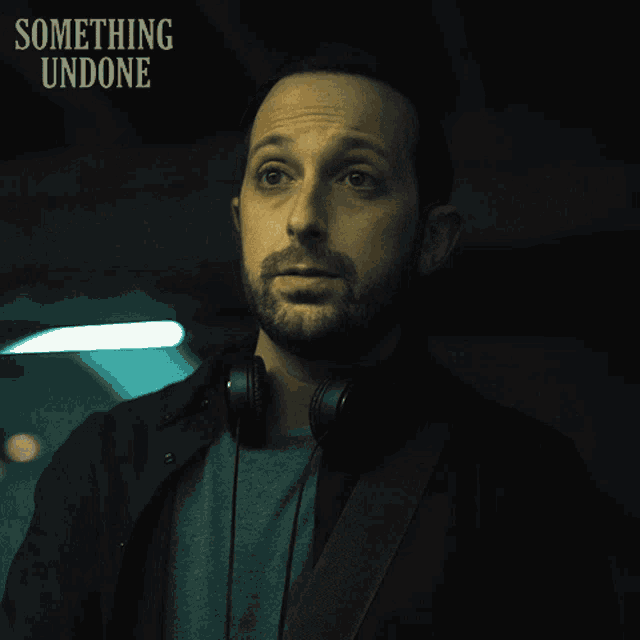 a man wearing headphones says " okay " in a dark room