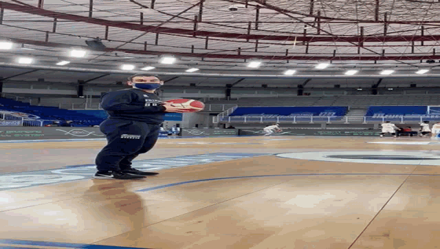 a man holding a basketball on a basketball court