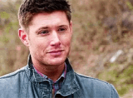 a man wearing a blue jacket and a plaid shirt is looking at the camera .