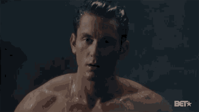 a shirtless man is taking a shower and the bet logo can be seen in the corner