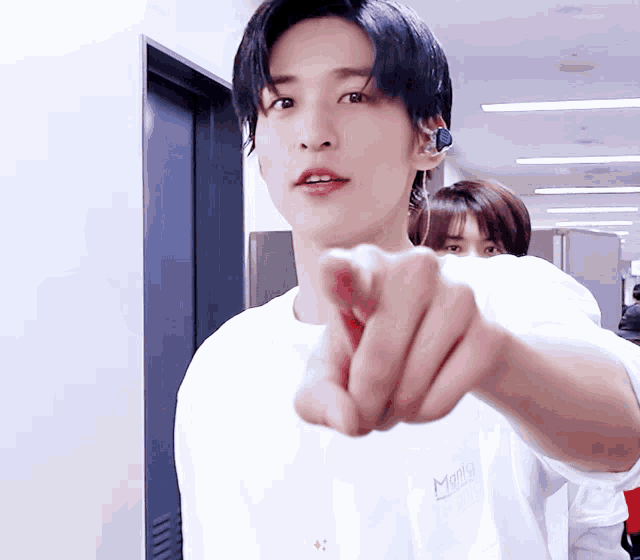 a young man wearing a white shirt with the letter m on the front