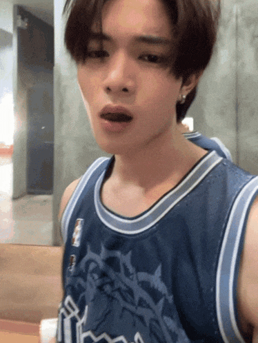 a young man wearing a blue tank top that says magic