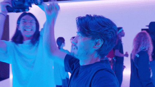 a group of people are standing in a room with blue lights on
