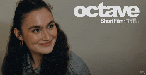 a woman is smiling in front of a poster for octave