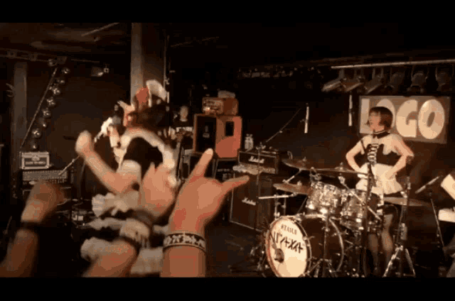 a drum set with a logo on the wall behind it