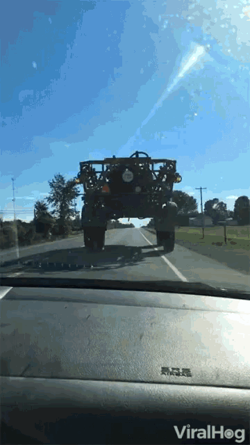 a car is driving down a road with a viralhog sticker on the dashboard