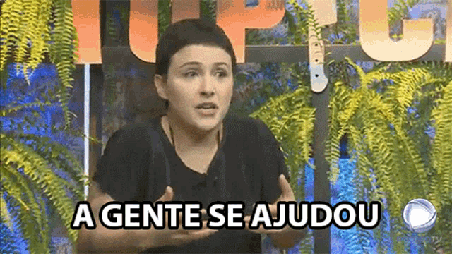 a woman is standing in front of a sign that says a gente se ajudou on it .