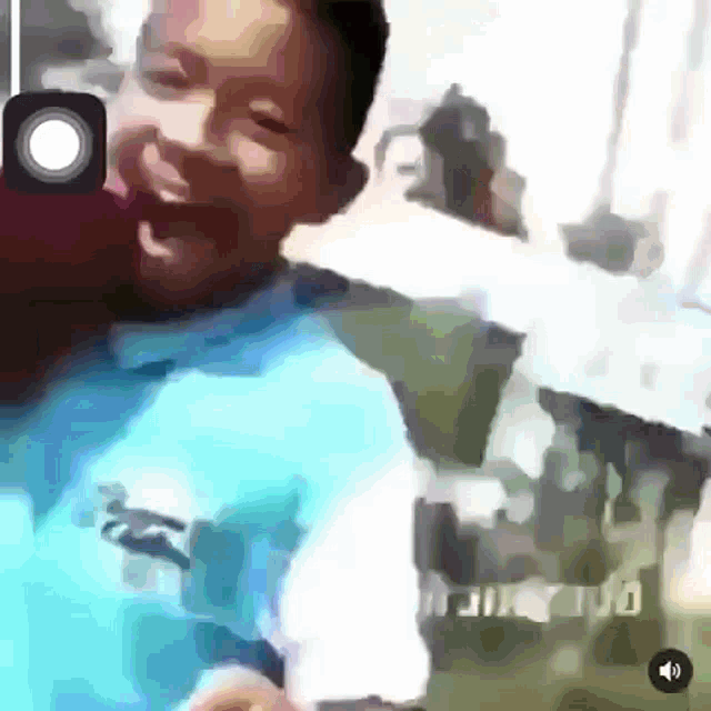 a man in a blue shirt is laughing in a video