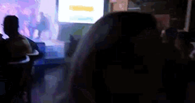 a group of people sitting in a dark room with a projector screen behind them