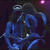 a man in a cowboy hat is singing into a microphone while playing a guitar on a stage .