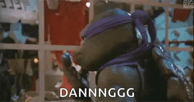 a teenage mutant ninja turtle wearing a purple mask is holding his hand to his face and making a funny face .