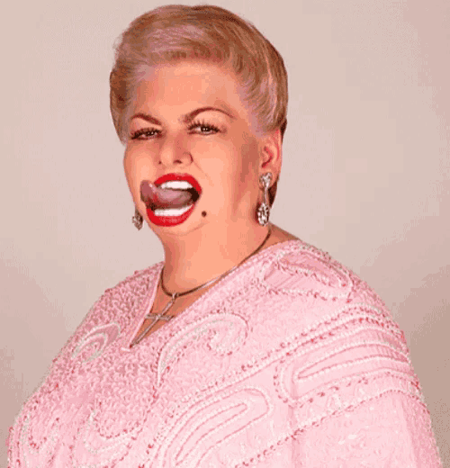 a woman in a pink dress has her tongue hanging out