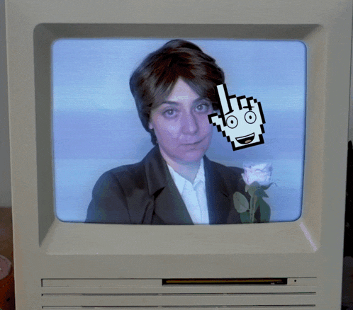 a computer monitor shows a woman holding a rose and a pixelated hand pointing at her
