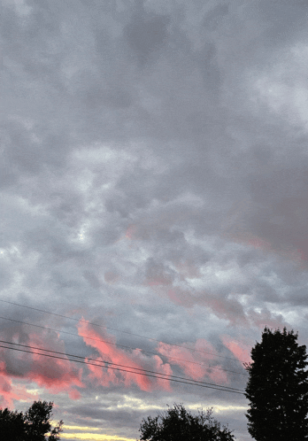 a cloudy sky with a pink cloud in the middle