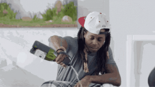 a man is pouring a bottle of champagne into his mouth