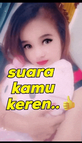 a girl holding a hello kitty stuffed animal with the words suara kamu keren written above her