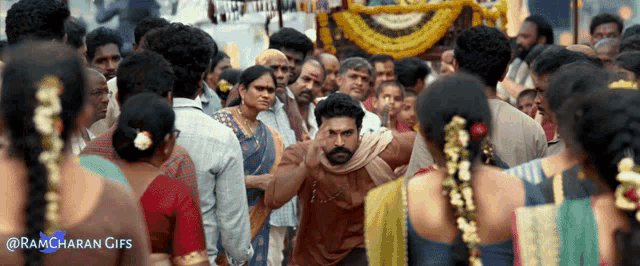 a ramcharan gifs shows a man standing in a crowd