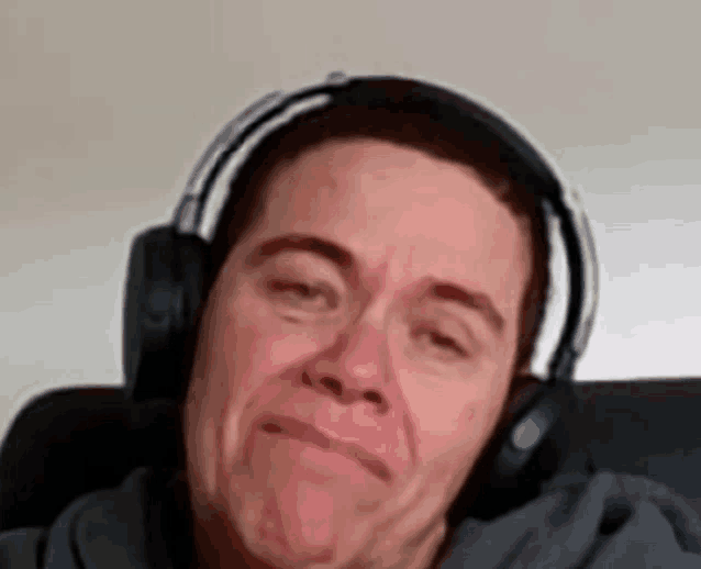 a man wearing headphones is making a sad face