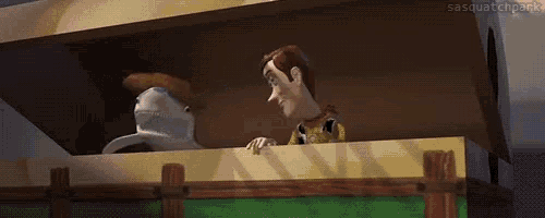 woody from toy story is standing on a wooden fence talking to a shark .