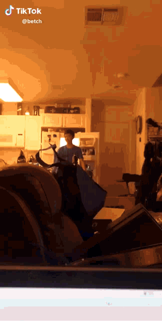 a screenshot of a tiktok video shows a man in a kitchen
