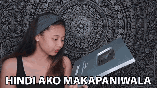 a girl holding a book with the words hindi ako makapaniwala on the bottom