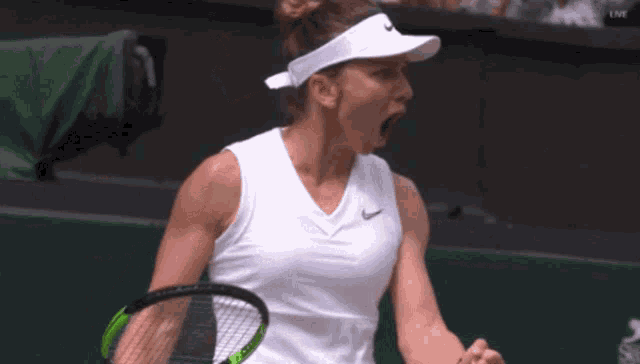 a tennis player wearing a nike visor is holding a tennis racquet