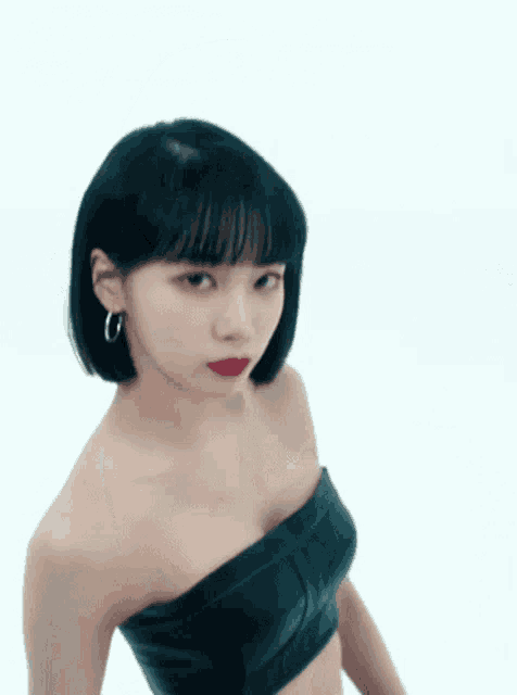 a woman is wearing a black strapless crop top and red lipstick .