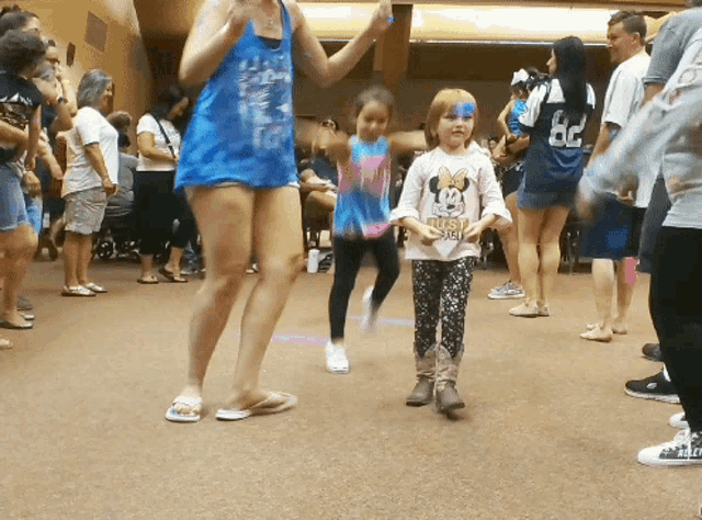 a girl in a minnie mouse shirt is dancing