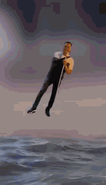 a man is flying through the air while holding a bottle in his hand