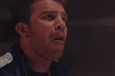 a close up of a man 's face with a shocked look on his face