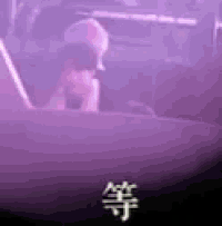 a man is sitting in the back seat of a car with a purple light behind him .