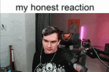 a man is sitting in front of a microphone in a room with the words `` my honest reaction '' written above him .