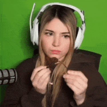 a woman wearing headphones is eating a chocolate bar .