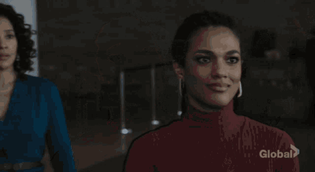 a woman in a red sweater is smiling and looking at a man