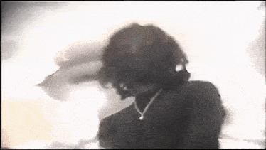 a black and white photo of a woman wearing a necklace and a turtleneck .