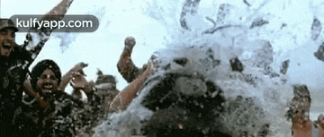 a group of people are standing in a pool of water and splashing water on each other .