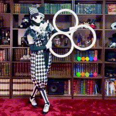 a clown is holding a pair of rings in front of a library